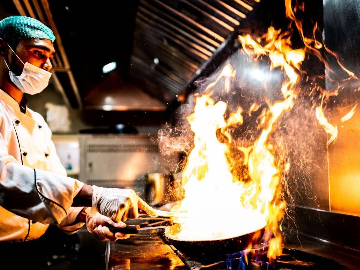 Chef cooking with a flame in a professional kitchen