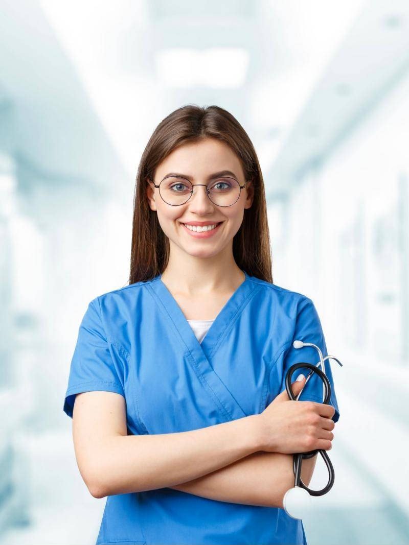 Young nurse in blue scrubs holding a stethoscope