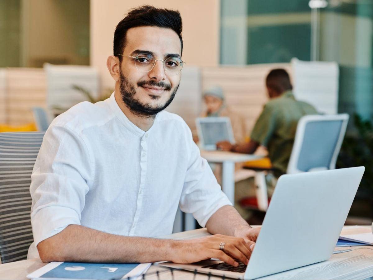 Young man smiling at his laptop